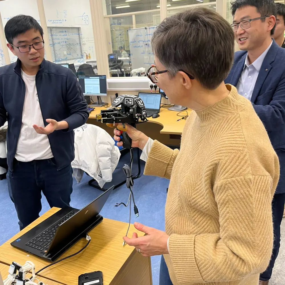 Image of Jenny Read in a lab speaking with Robot Dexterity Creators