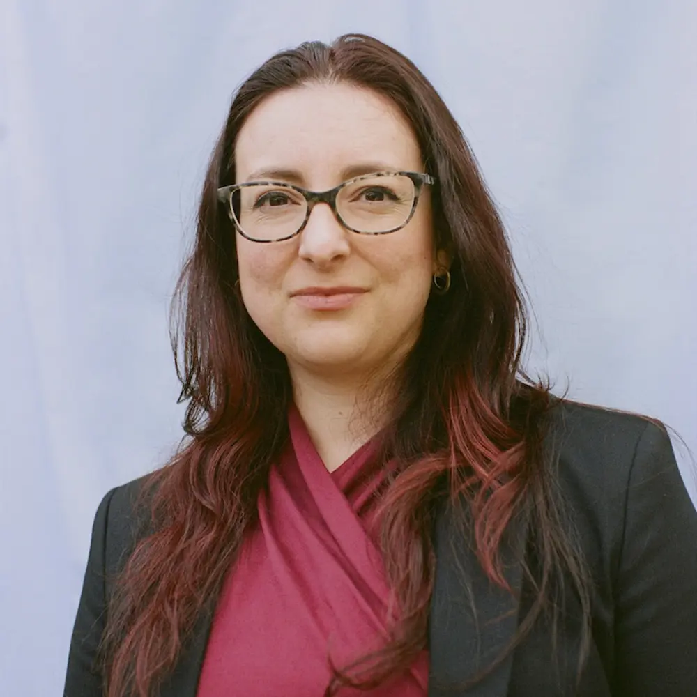 Photo of Nicole Wheeler smiling in front of a blue background