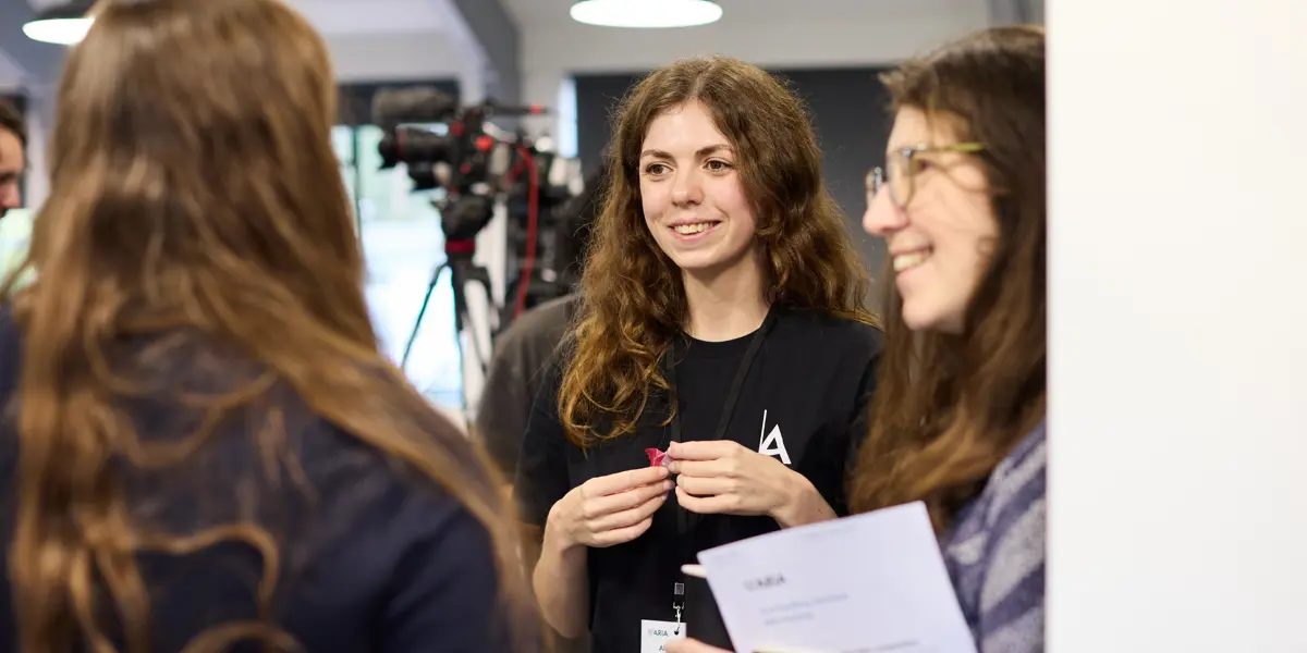 Three women standing in an office having a discussion