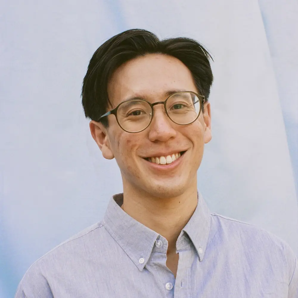 Photo of Ivan Jayapurna smiling against a blue background